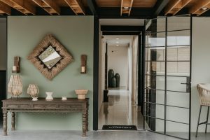 olive green walls with artisanal accessories and art deco glass door