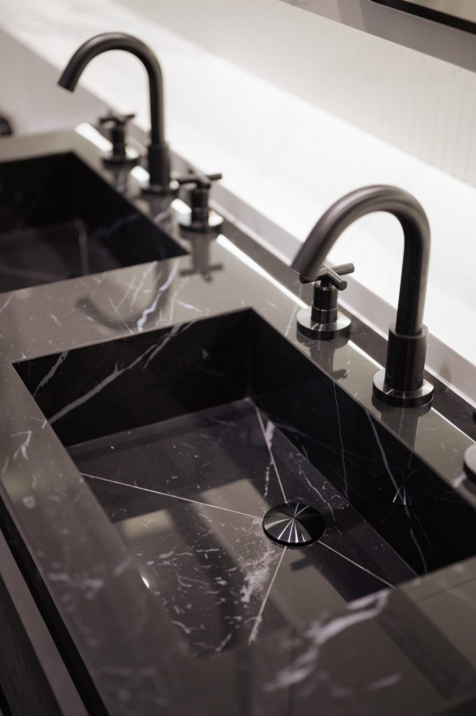 Black marble-like bathroom with taps