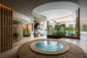 circular serenity pool below circular lighting with mosiac and plants in spa in Hilton Lisbon