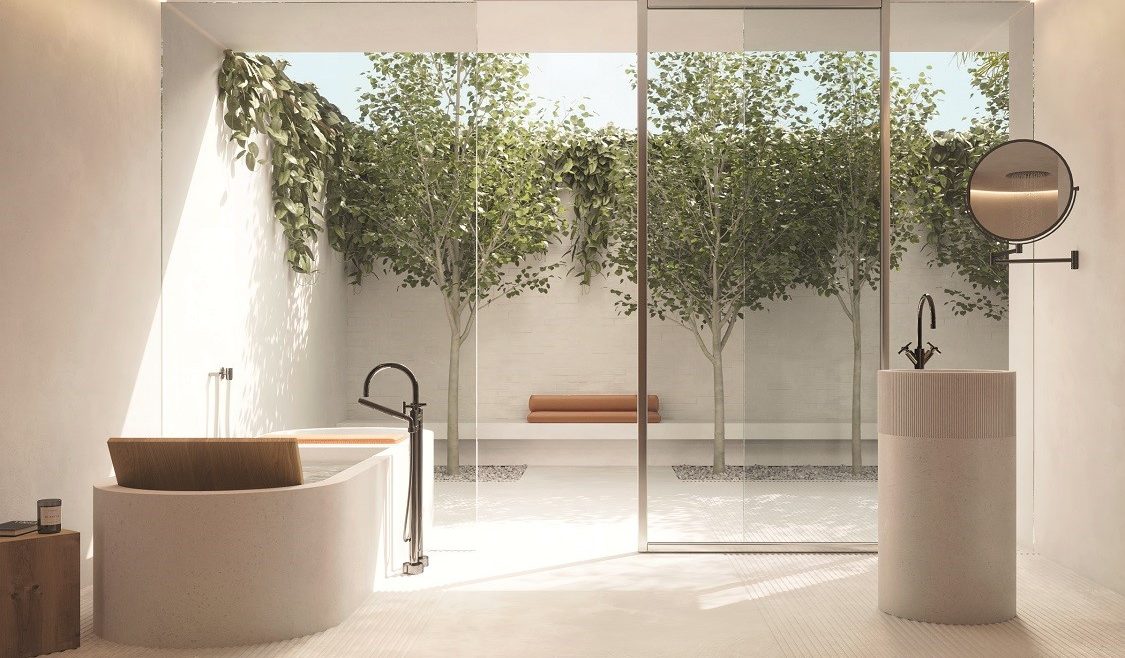 a light and stone coloured spa bathroom with glass doors surrounded by plants. Fittings from Dornbracht