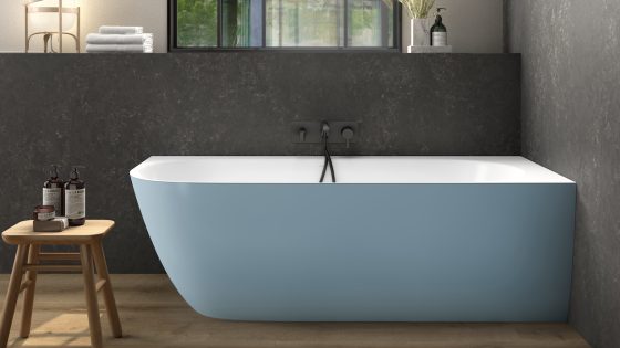 A light blue, matt bath in corner of modern bathroom