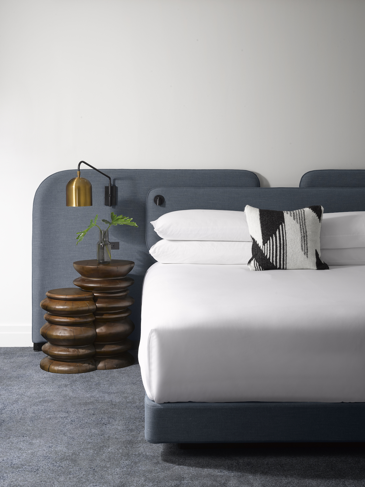 Blue headboard in hotel with quirky side table