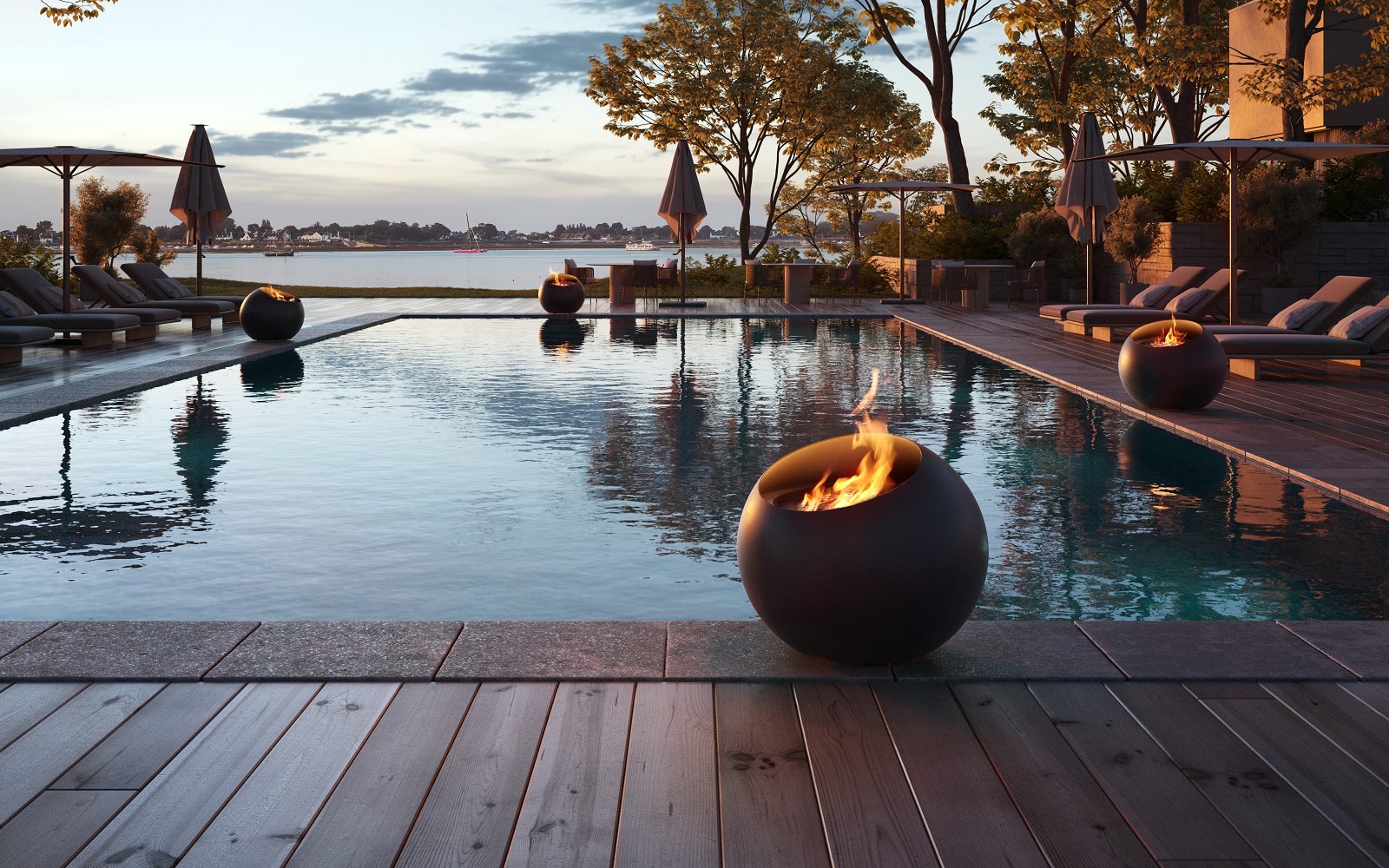 FOCUS bubble fireplace on the edge of a swimming pool overlooking a lake