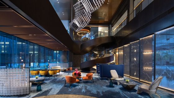 glass walls with a suspended sculptural light in the lobby of voco Hefei Binhu China