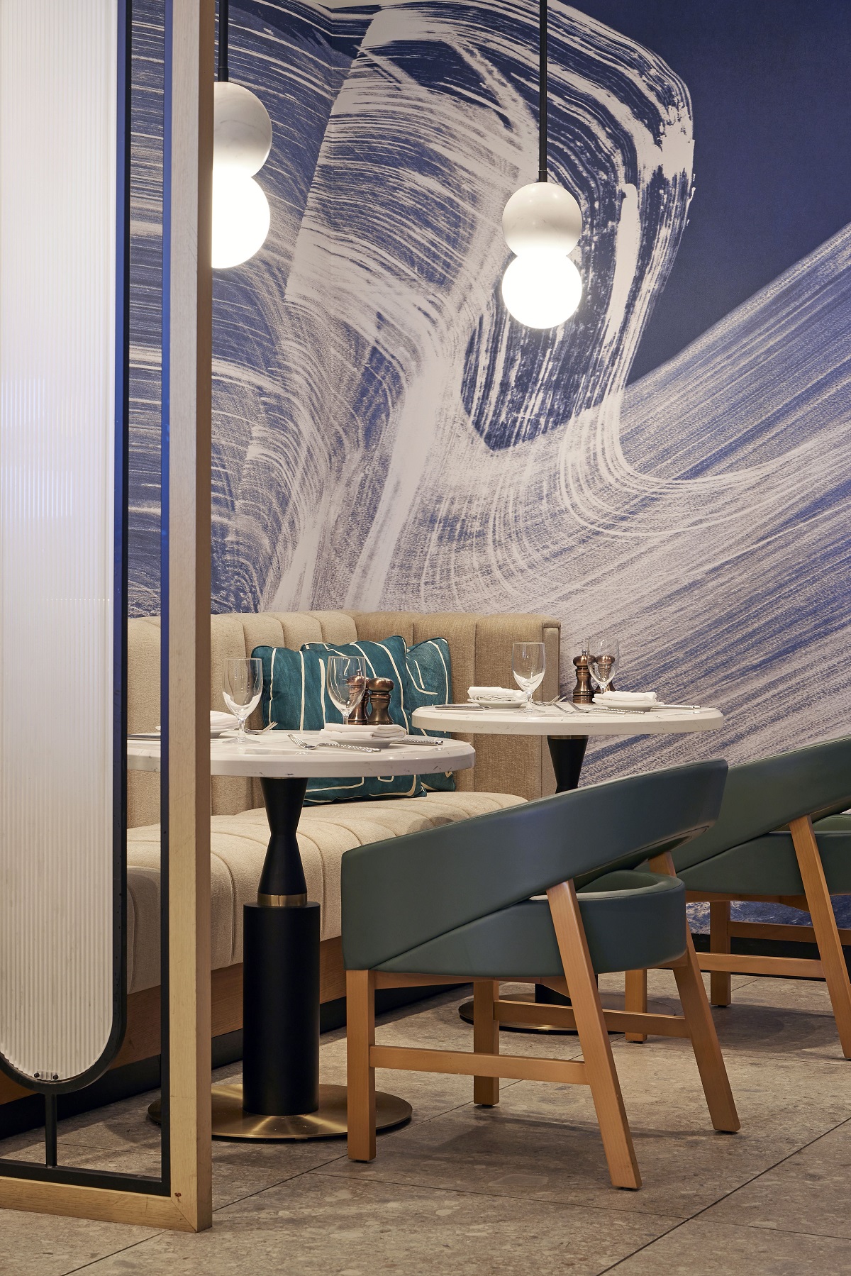 restaurant seating in cubicles with abstract wave like wall painting behind