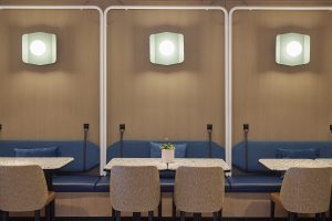 blue banquette seating in M Club Miami with porthole window lighting above. Design by HBA for Miami Marriott Biscayne Bay