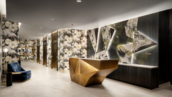 A lobby in a hotel with geometric desk and wild wallcoverings