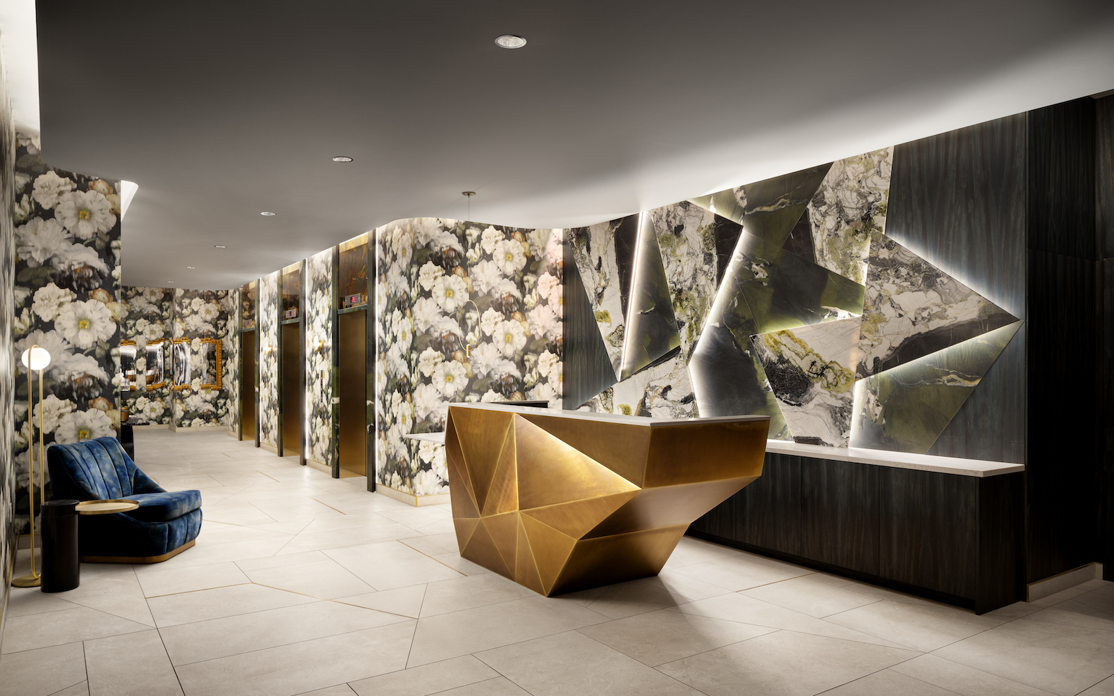 A lobby in a hotel with geometric desk and wild wallcoverings