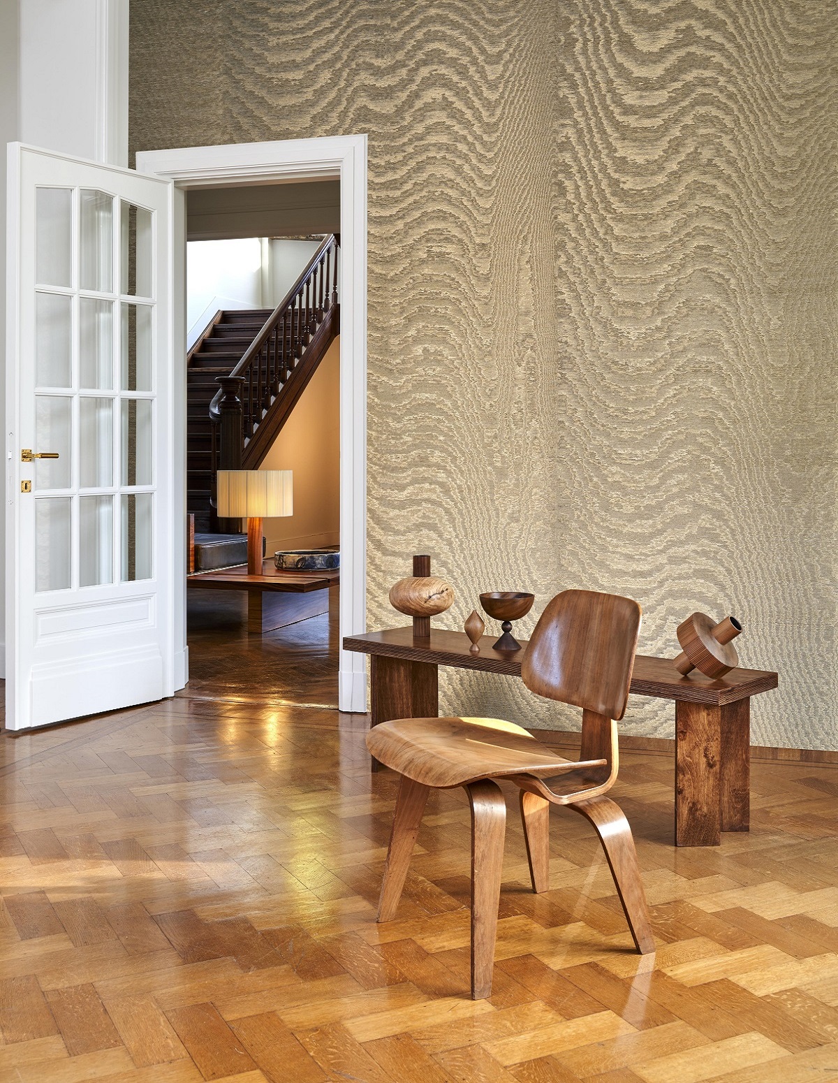 wooden parquet flooring in a period house with modern wooden chair and moire wallcovering