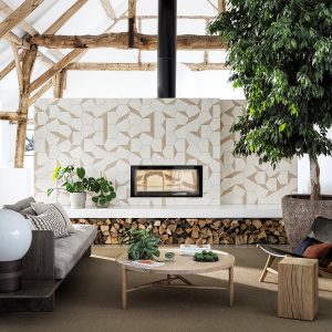 tiled patterned wall behind the fireplace with wooden beams above and tiles from Bert & May collection at Hyperion Tiles