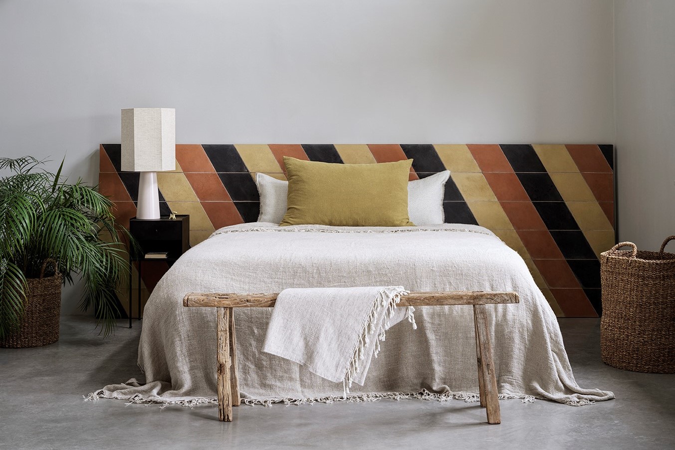 brown and black striped tile as headboard behind the bed. Bert & May encaustic tiles from Hyperion Tiles