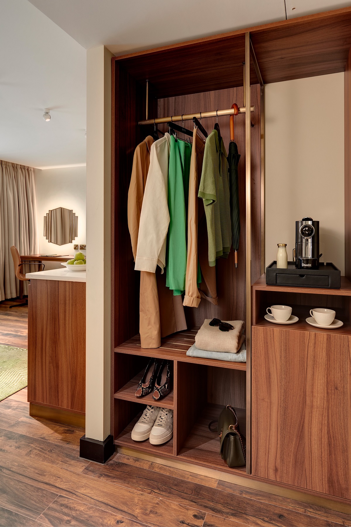 open wardrobe in guestroom with coffee machine and cups alongside