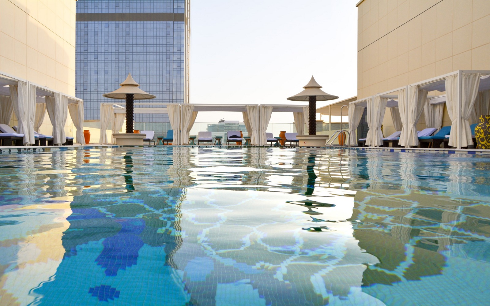 view across swimming pool with mosaic arabesque tiled floor at the Andaz Dubai