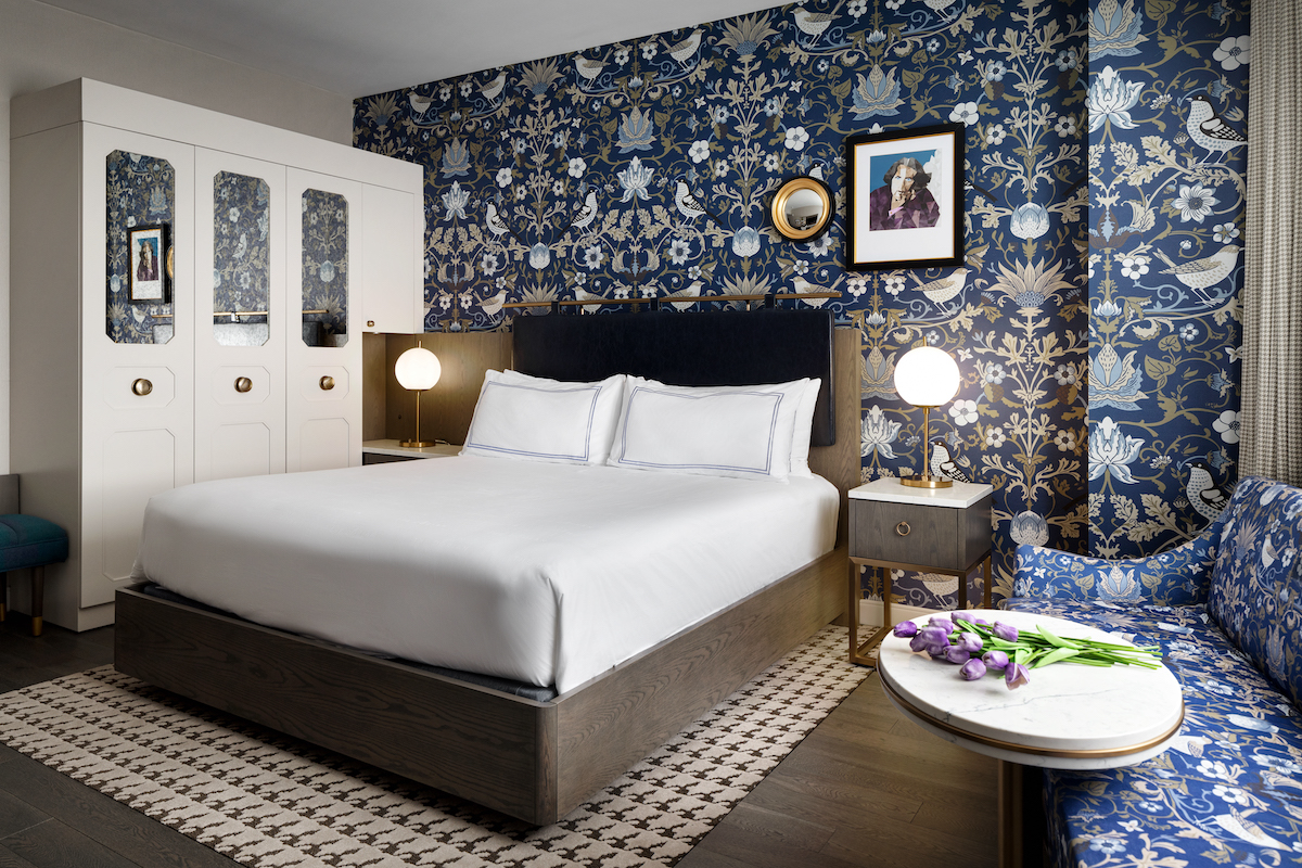 Hotel bedroom with brass detailing and loud wallcoverings