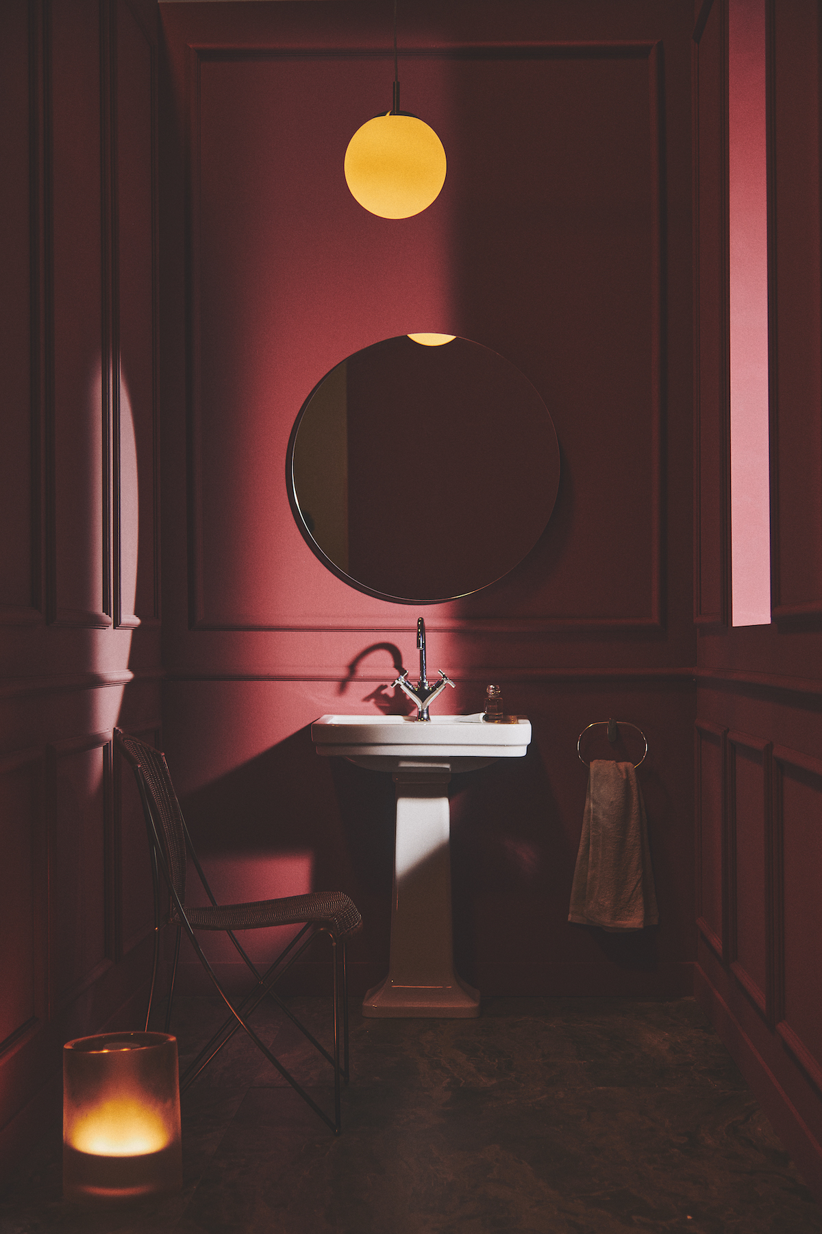 A dark red bathroom with white basin