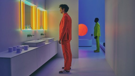 Man in orange suit and man in green suit in retro bathroom
