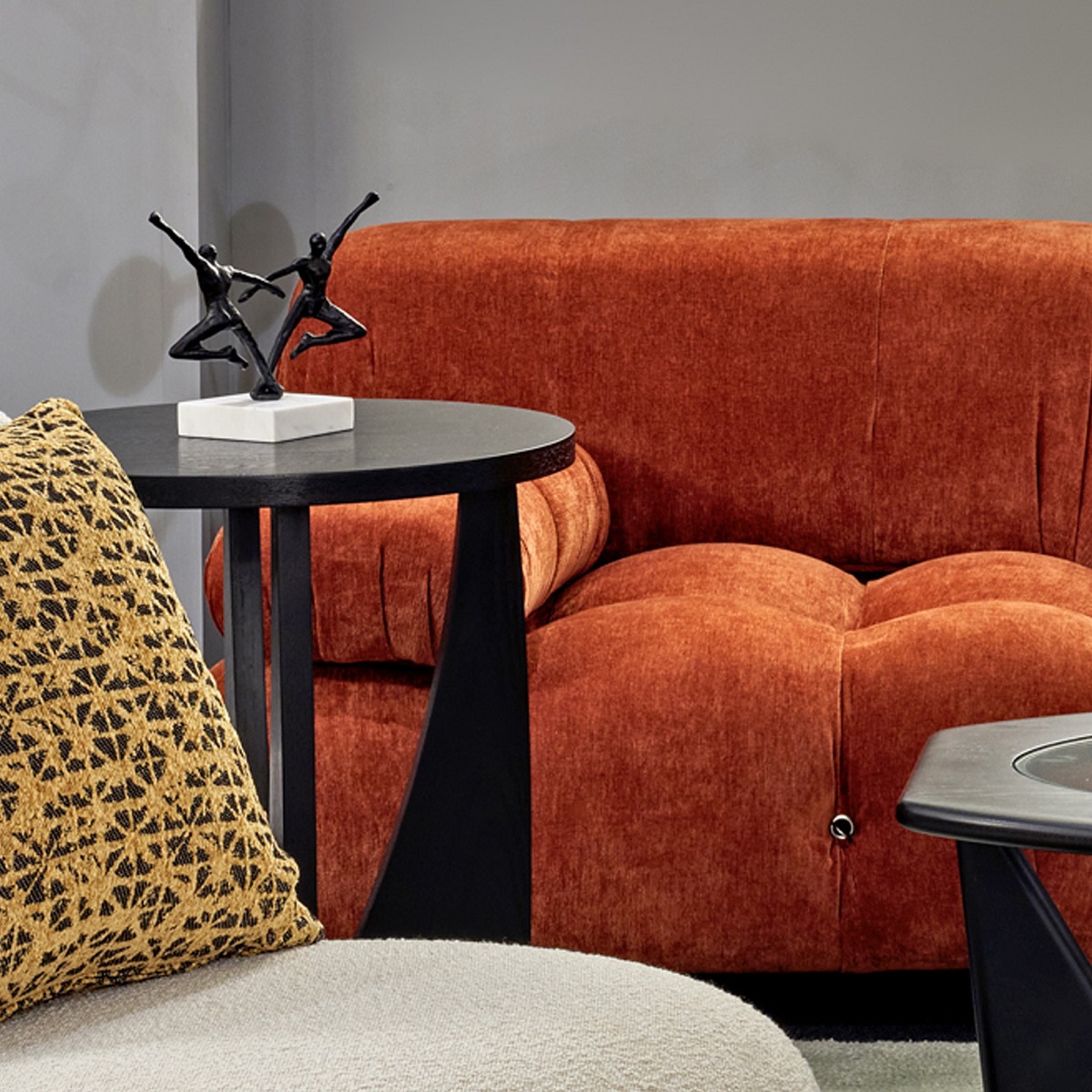 Bourne black sidetable next to soft orange couch