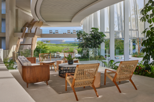 wooden furniture in front of curved facade and panoramic windows in the lobby in The St. Regis Kanai Resort 