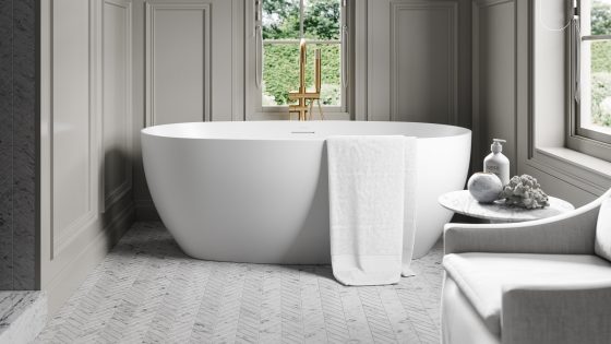 freestanding acrylic bath in a grey panelled bathroom with french sash windows. Bath by Lusso