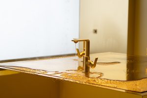 Yellow room adn gold tap spilling over table
