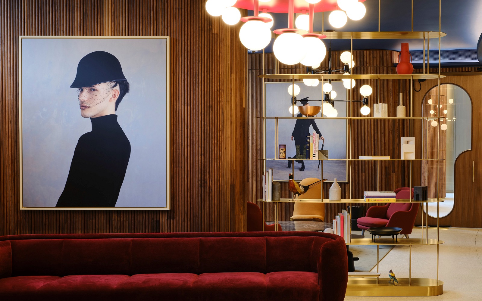 contemporary artwork against wooden panelled wall with rust velvet couch and statement lighting in lobby of art'otel London