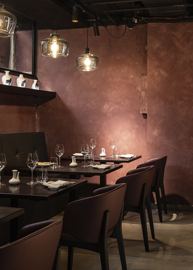 textured dark brown walls and wooden furniture in Aki restaurant in Malta designed by Jestico + Whiles