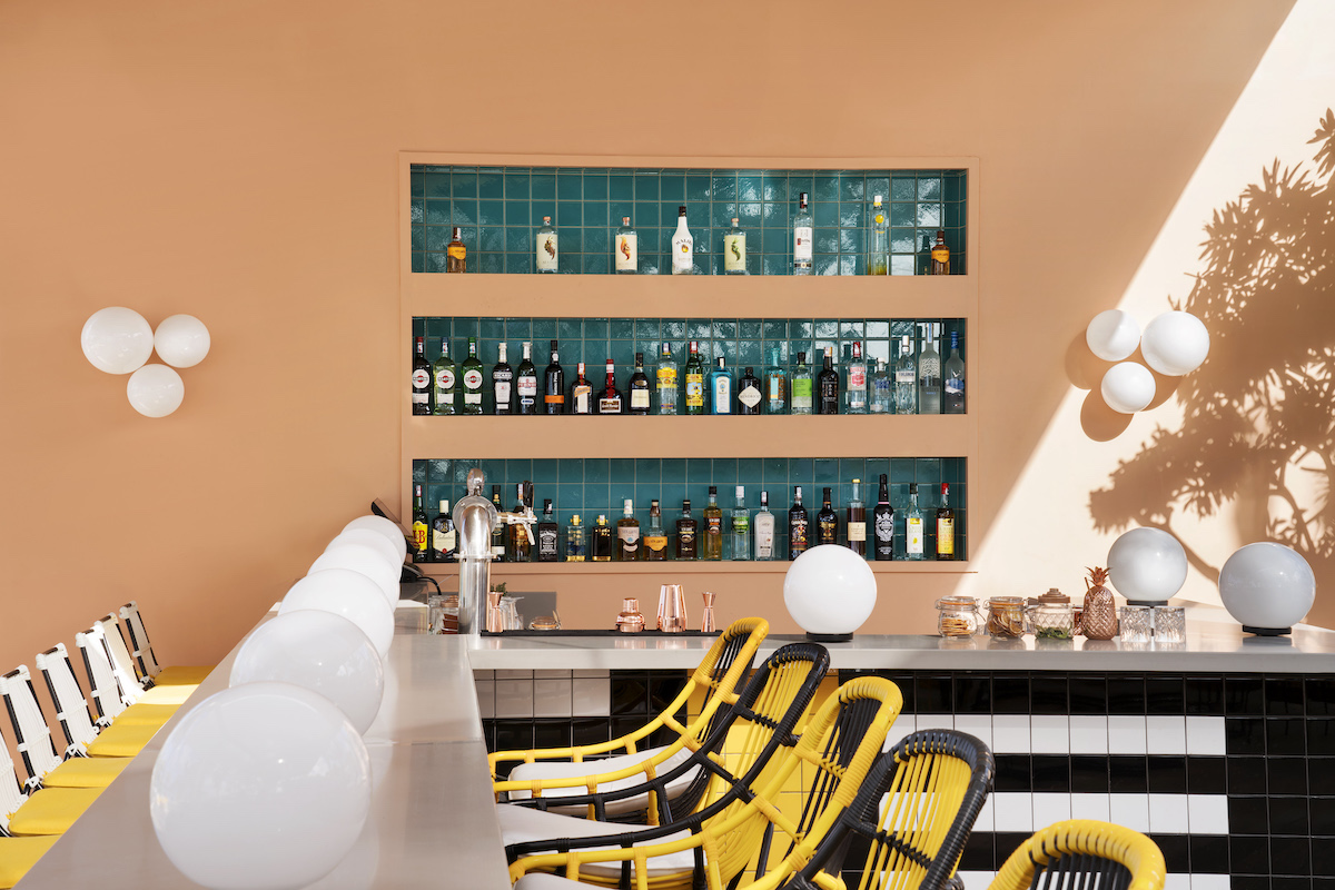 Beach bar with orange walls and black and yellow bar stalls