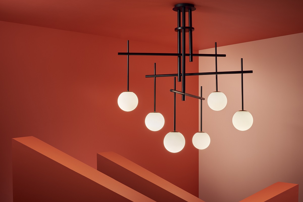 contemporary lighting design with black structure and round glass shades by Chelsom against a terracotta background