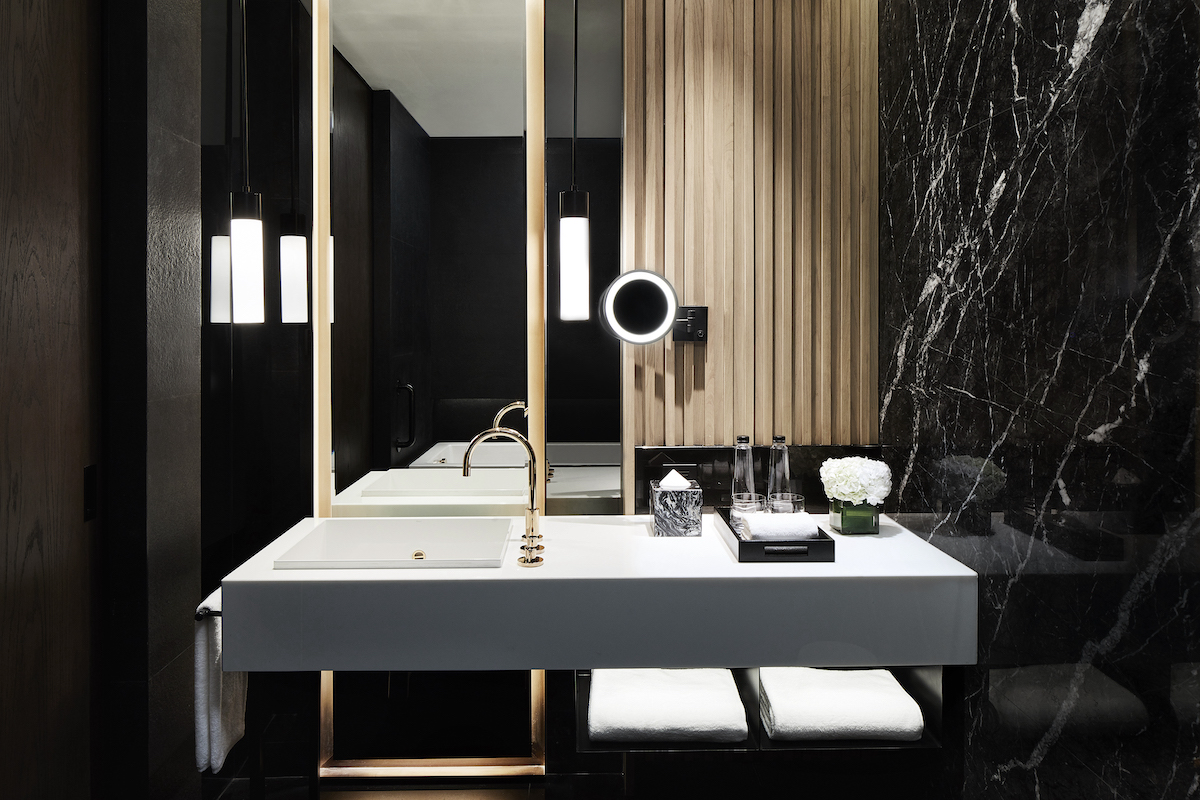 Dark, luxury marble bathroom with gold accents