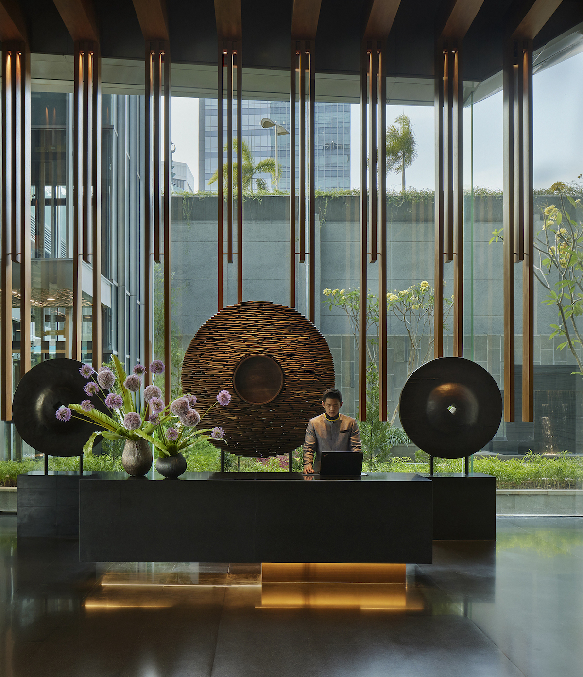 A dramatic lobby inside Park Hyatt Jakarta with gongs as backdrops