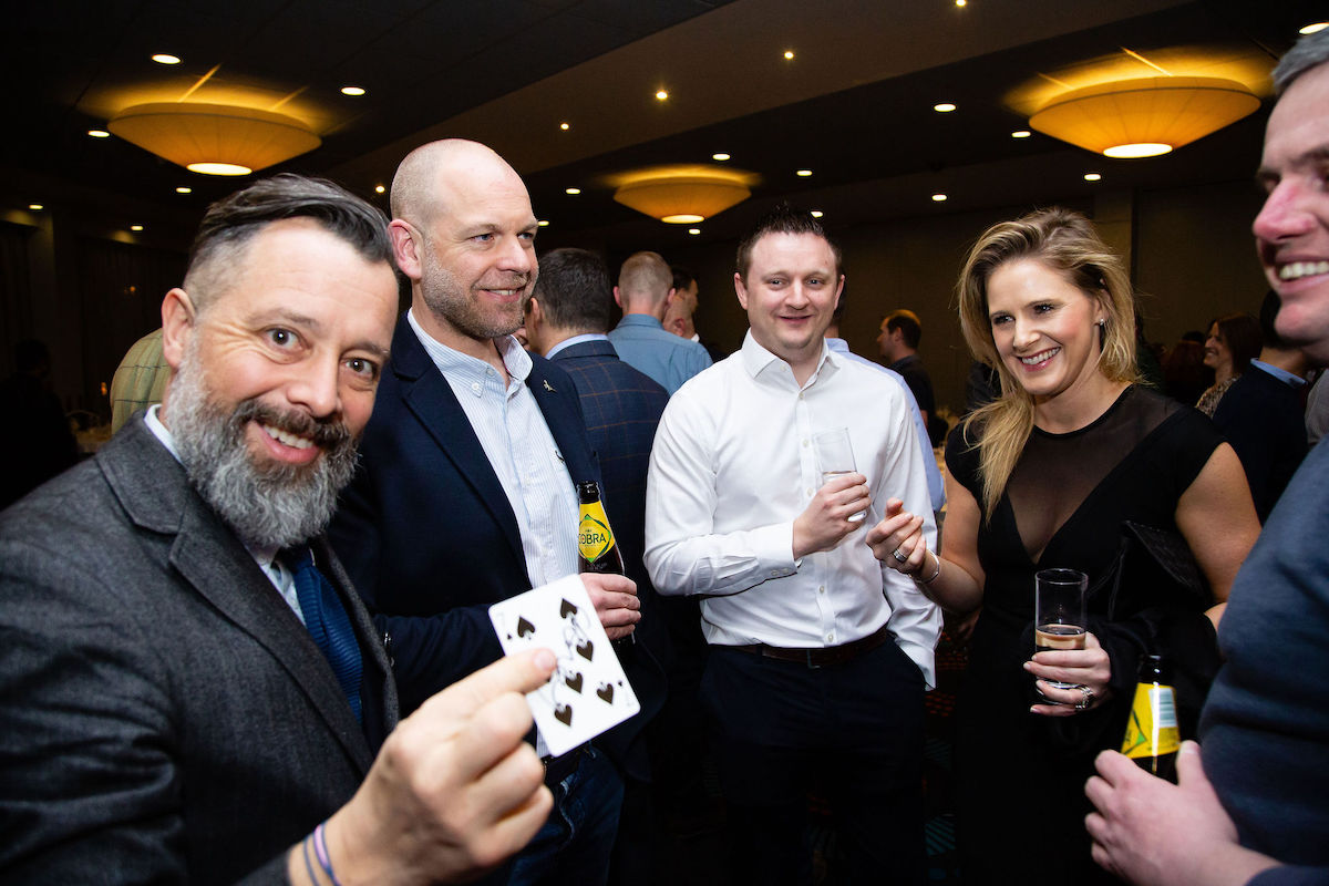 Industry professionals networking at an event with magician