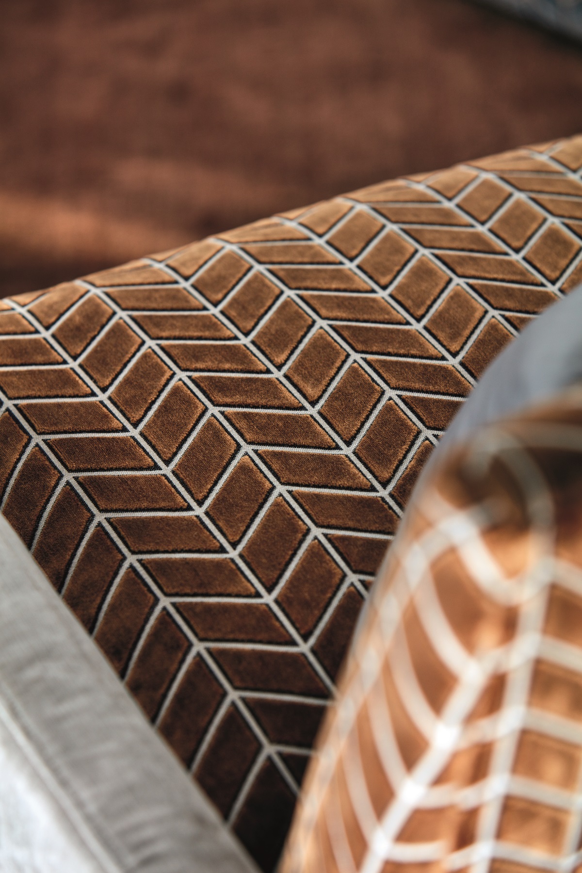 close up image of herringbone textured velvet fabric in brown by Harlequin