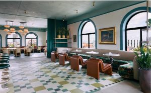 patterned tiled floor and mid century leather furniture in bar at Hotel Genevieve