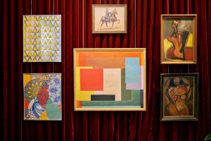 eclectic mix of art framed against a velvet draped background in the lobby at Hotel Genevieve
