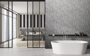 bathroom with patterned Newmor wallpaper and bedroom through black glass doors
