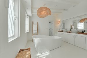 secret suite bathroom in white with white freestanding bath and natural lampshade and details
