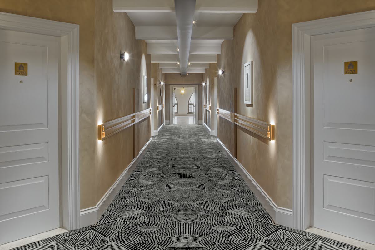 Contemporary corridors with geometric pattern carpets and light walls inside Hilton Venice
