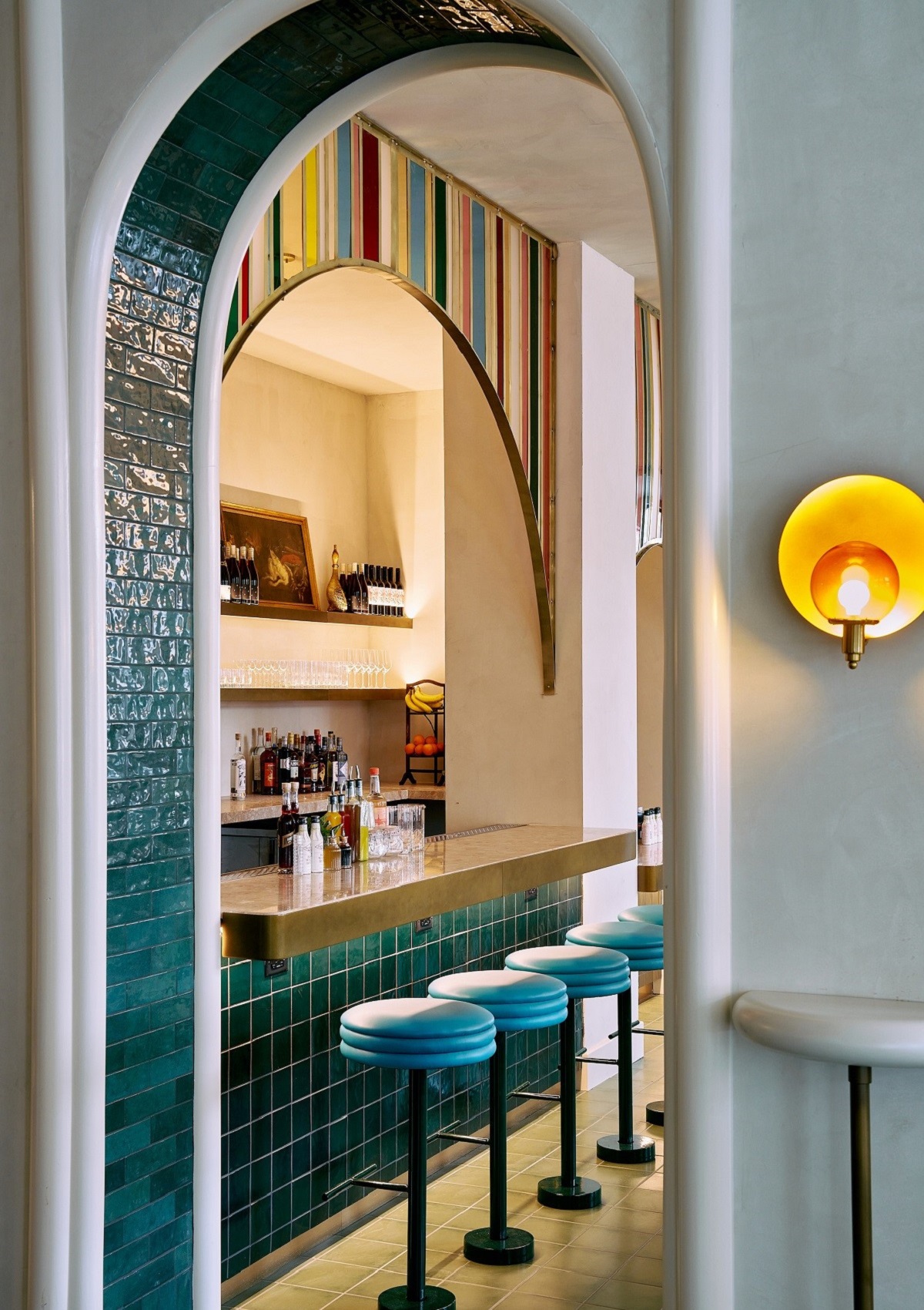 view through tiled archway to bar with seating and striped and tiled detail
