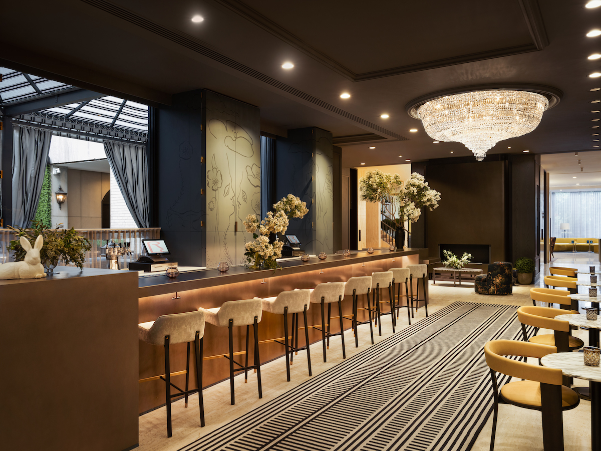 Warm, inviting bar with luxury design details such as large chandelier and high ceilings