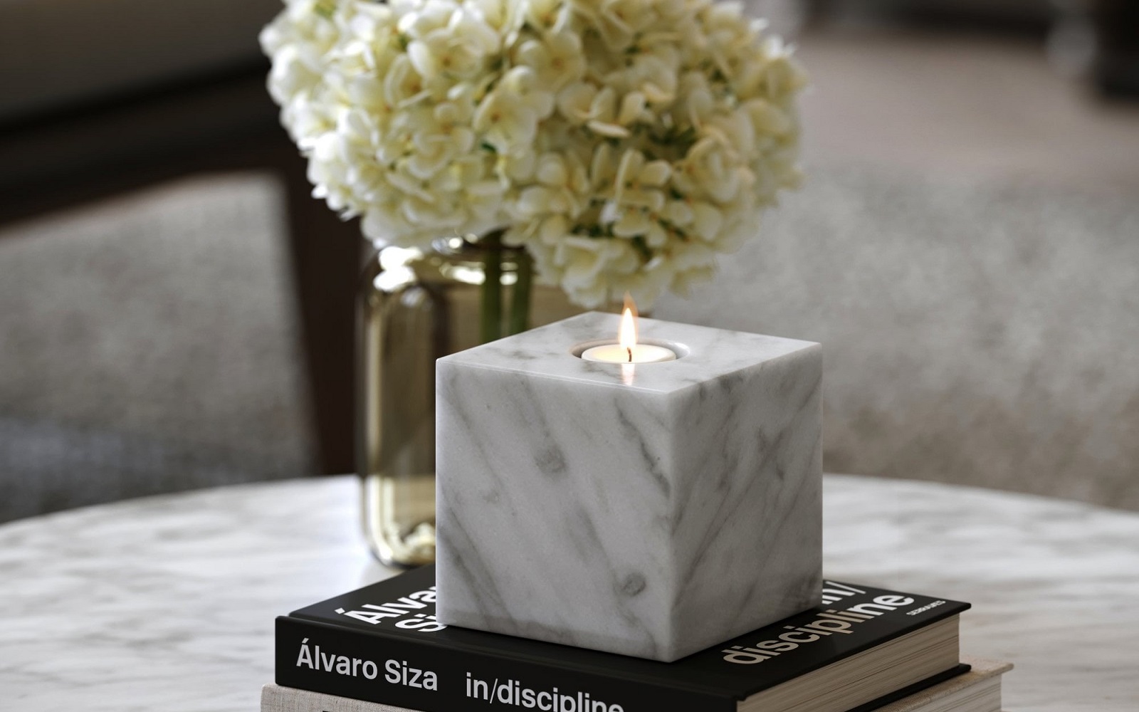square marble candleholder by Lusso on a pile of books and a vase of flowers