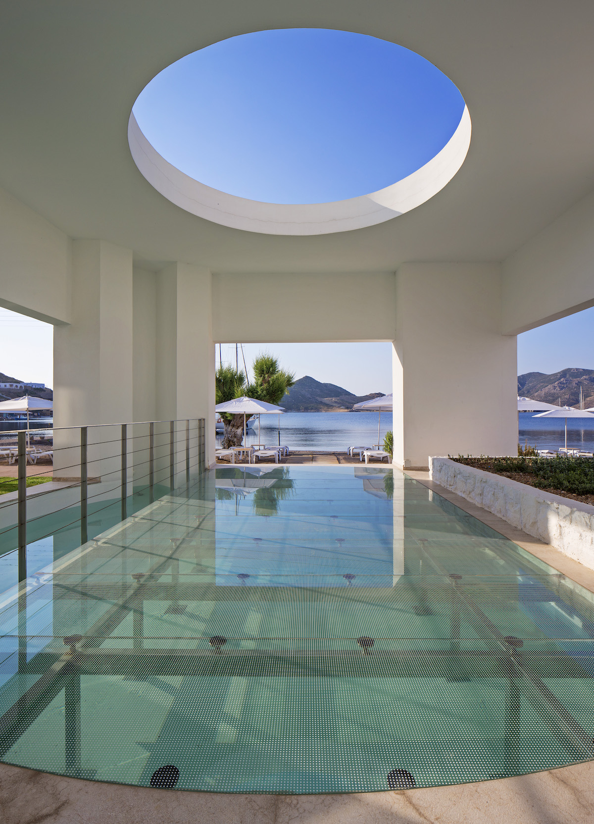 Pool overlooking ocean in greece wiht circle cut-out in architecture