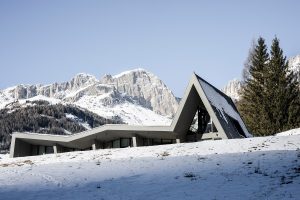view across snow to hotel facade by NOA imitating the shape of the mountains behind