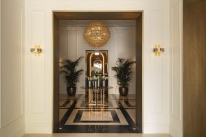 hotel entrance with black and white marbel floor, central chandelier and palm trees