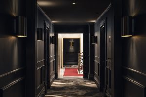 dark painted corridors leading to guestrooms from light stairway