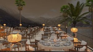 outdoor dining area with tables set and lanterns lighting the views across the sea to the mountains in Montenegro