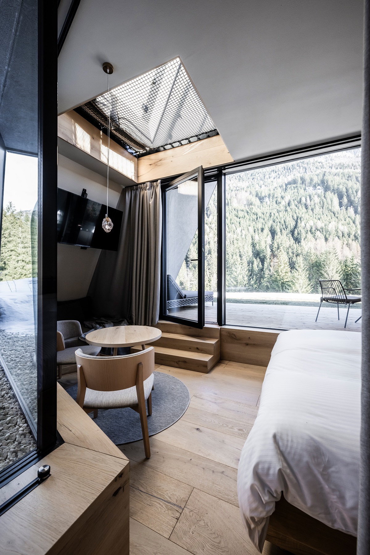 view from guestroom to mountains showing angular glass corners of the windows and a skylight