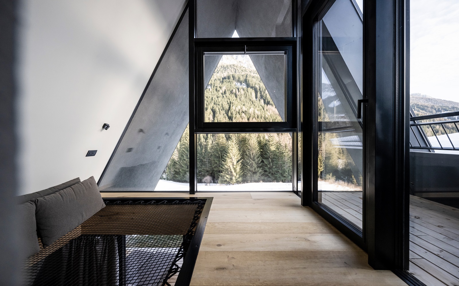 A-frame view onto mountains from loft Olympic Spa Hotel in Val di Fassa designed by NOA