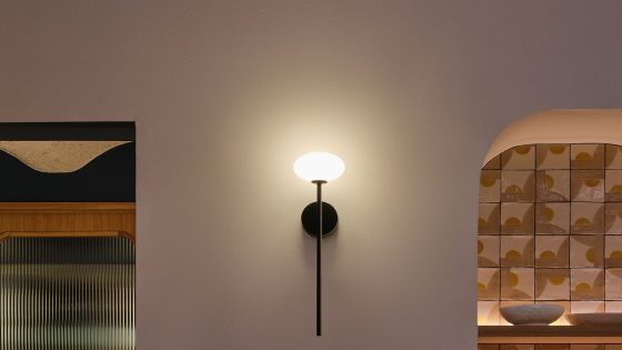 single black Bloom wall light by LEDSC4 on cream wall with patterend tiles in background