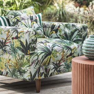 close up of chair covered in tropical fabric pattern on an outdoor wooden deck