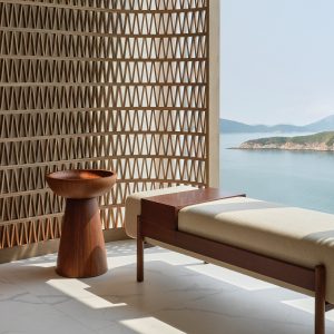 latticed wood screen detail with wooden table and bench in front of window overlooking the sea by Blink design at Fullerton Ocean Park Hotel